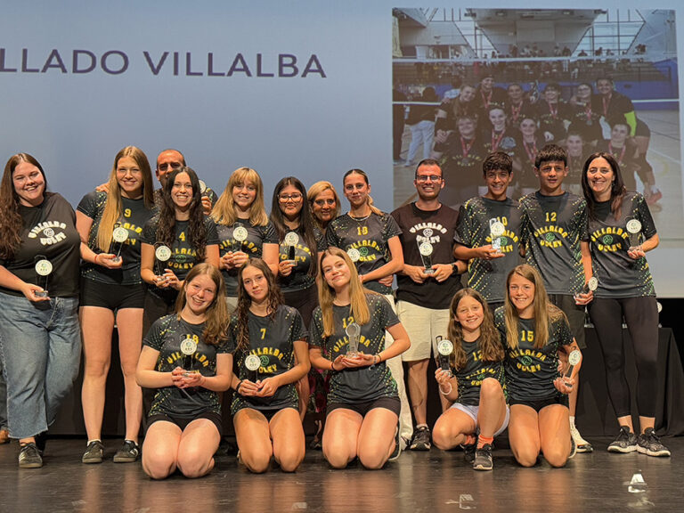 Un equipo de jóvenes atletas femeninas, algunas arrodilladas, posando con sus trofeos y medallas en un escenario durante la XV Gala del Deporte ADS.