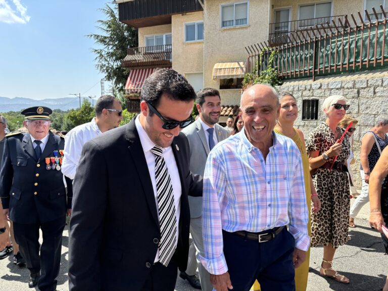 El alcalde Sergio Yunquera (tercero desde la izquierda) sonriendo y caminando en un evento festivo en Mataelpino, acompañado por otras autoridades y vecinos.