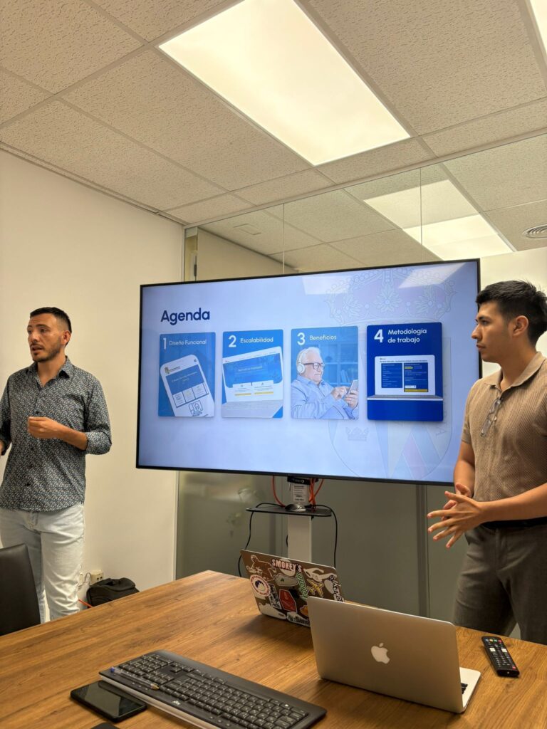 Pantalla mostrando la "Agenda" y metodología de trabajo para el desarrollo de la nueva web de El Boalo, Cerceda y Mataelpino, con presentadores y un portátil en primer plano.