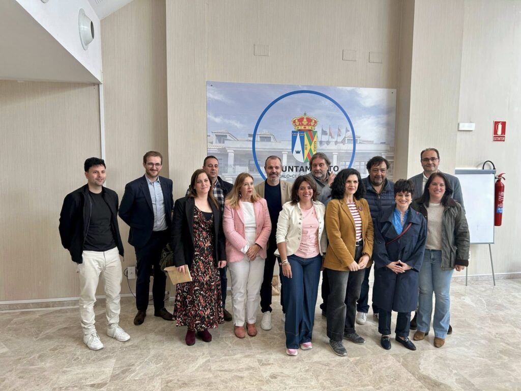 Grupo de profesionales y representantes institucionales, incluyendo a la concejal de Promoción Municipal y Turismo de El Boalo, Cerceda y Mataelpino, frente a un panel con el escudo municipal.