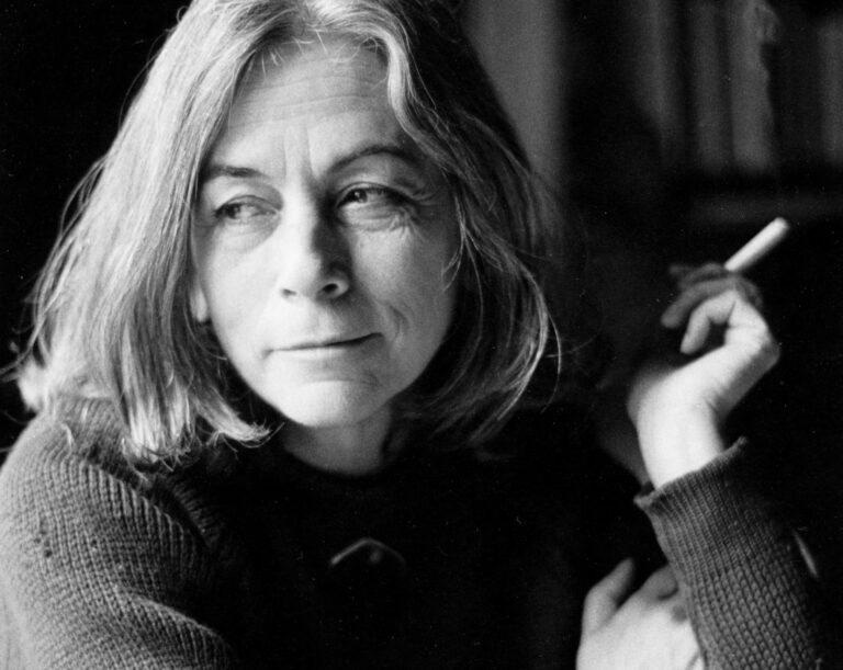 Retrato enmarcado de Carmen Martín Gaite, con flores frescas adornando su base, simbolizando el legado literario que el Ayuntamiento de El Boalo, Cerceda y Mataelpino honra con el premio de narrativa.